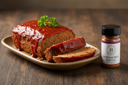 Classic meatloaf on a rustic platter with a bottle of Breeze Blends Steakhouse Blend seasoning