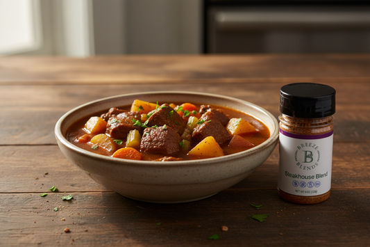 Steakhouse beef stew with tender beef chuck, carrots, celery, and potatoes in a rich broth, garnished with fresh parsley and a Breeze Blends Steakhouse Blend bottle.