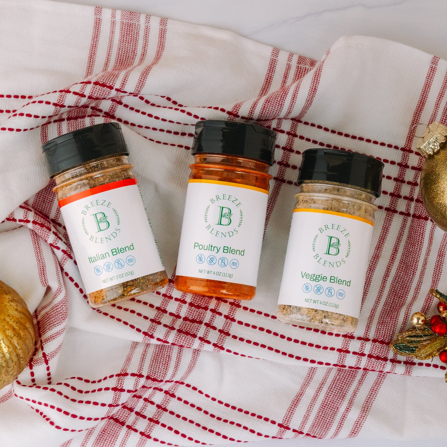 Breeze Blends three seasoning blends on a red and white checkered cloth with Christmas decorations.