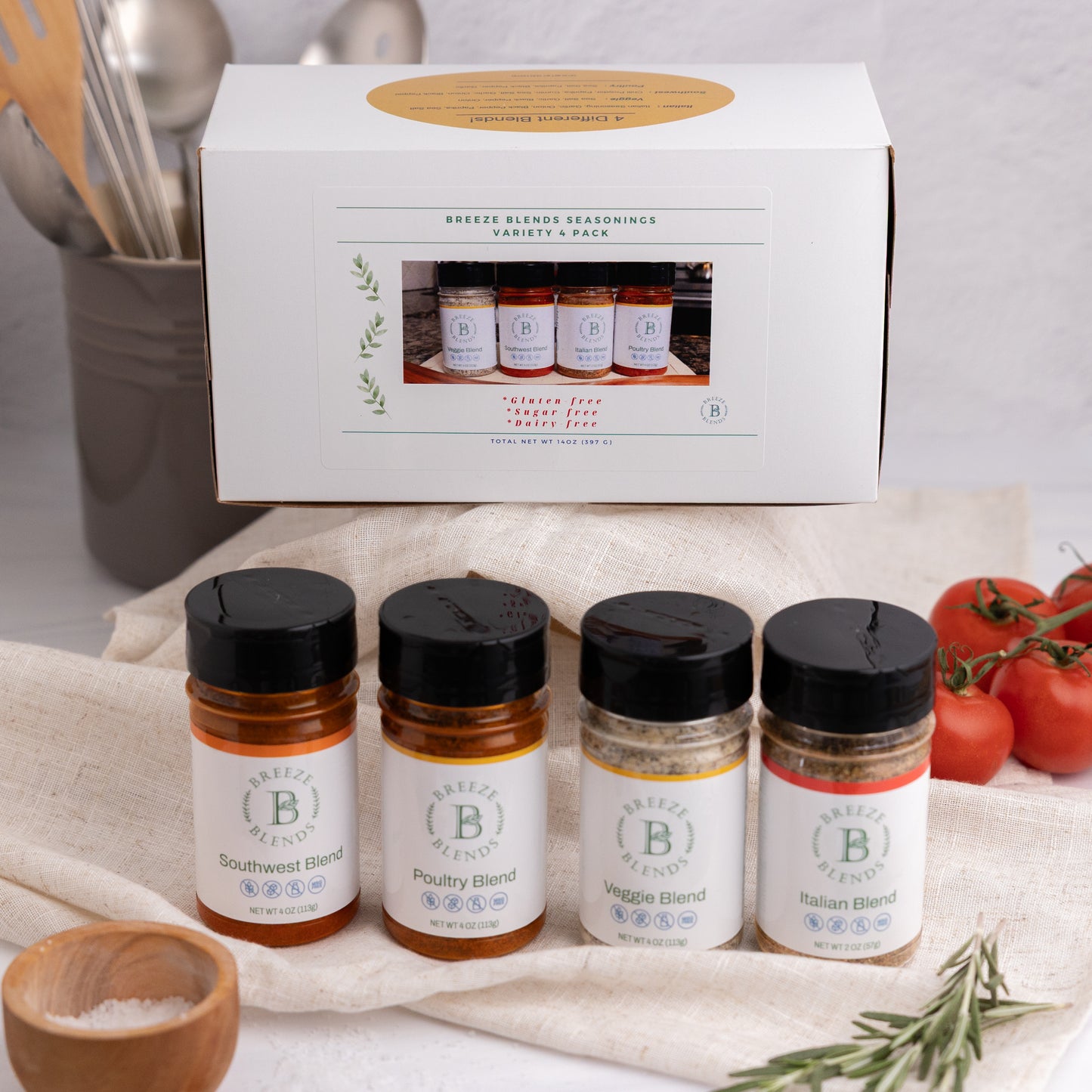Breeze Blends Variety 4 Pack box with individual bottles on a kitchen counter, with tomatoes and rosemary in the background. 