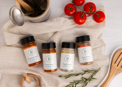 Breeze Blends Spice jars included in Variety 4 Pack on a kitchen towel with tomatoes and rosemary