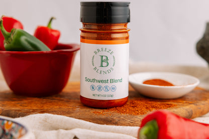 Bottle of Breeze Blends Southwest Blend on a wooden cutting board with peppers in the background
