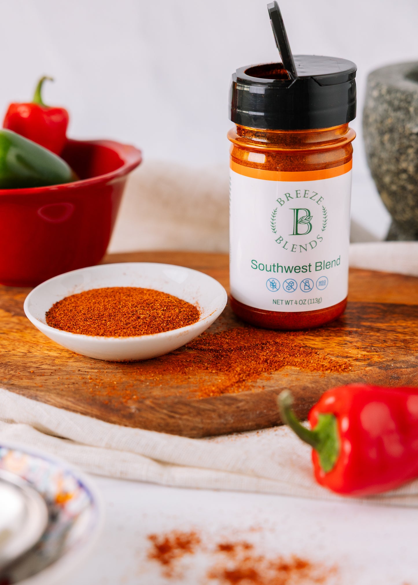 Bottle of Breeze Blends Southwest Blend on a wooden surface with peppers and spices.