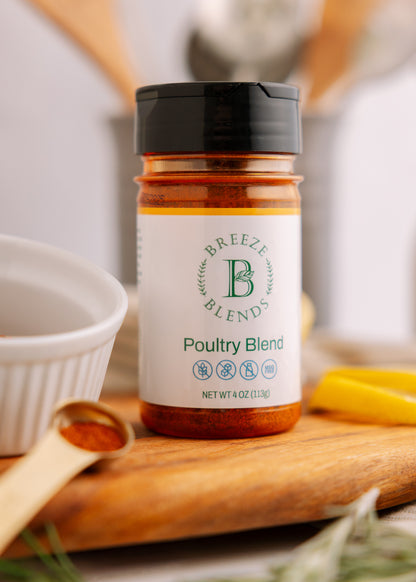 Breeze Blends Poultry Blend seasoning jar on a wooden cutting board with a spoon and bowl in the background.