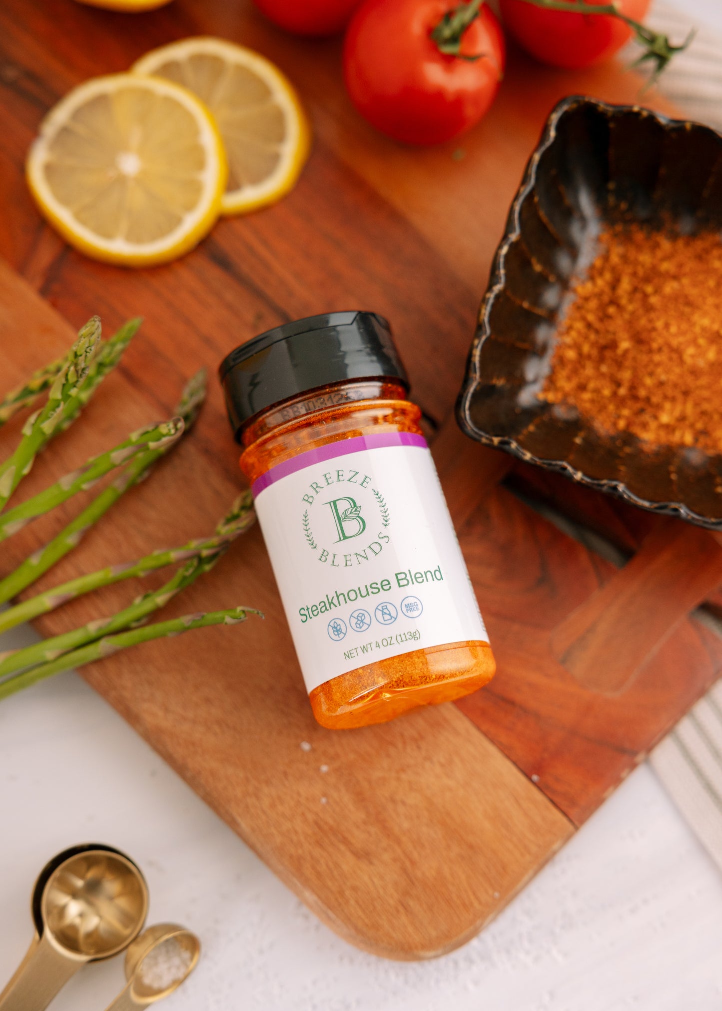 Bottle of 'Steakhouse Blend' seasoning on a wooden cutting board with vegetables.